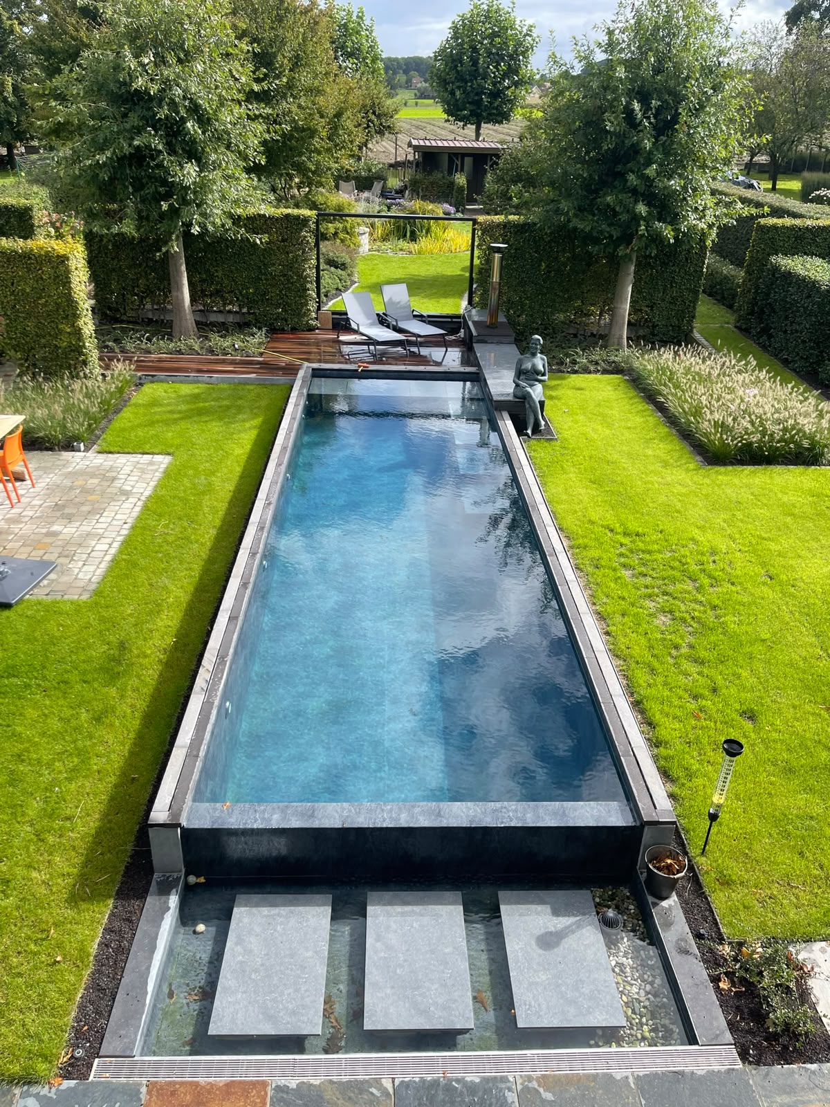 Strak zwembad in landelijke tuin met groene omgeving Roeselare